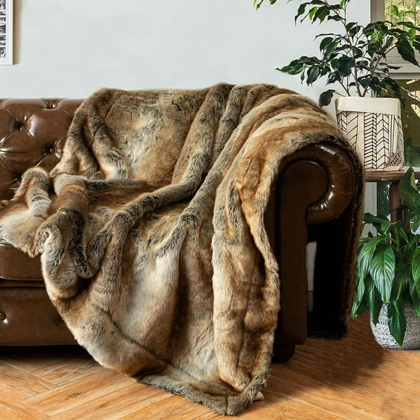 Brown Arctic Dream Faux Fur Throw Blanket draped over a couch from the right, showcasing its luxurious, European-inspired design and plush texture. Perfect for adding warmth and elegance to any space.
