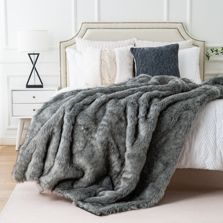 Gray Arctic Dream Faux Fur Throw Blanket draped over a bed, adding a touch of European elegance and luxurious comfort. Soft, plush, and perfect for enhancing your bedroom decor.