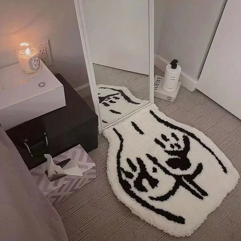 
The VibeCore Booty Handprints Accent Rug displayed in a bedroom setting, showcasing its playful black-and-white handprint design. This aesthetic rug adds a bold and quirky touch to the room, making it ideal as a fun rug for bedrooms or dorms. Its soft, plush texture enhances comfort, while the non-slip backing ensures safety. Perfect for modern, urban, or contemporary decor styles, this unique rug is both stylish and practical.