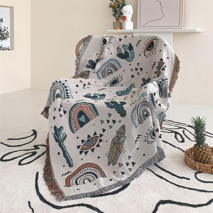 VibeCore Cactus & Crystals Woven Blanket draped over a chair, showcasing its earthy cactus and crystal design with soft, reversible cotton texture for a cozy, aesthetic touch.