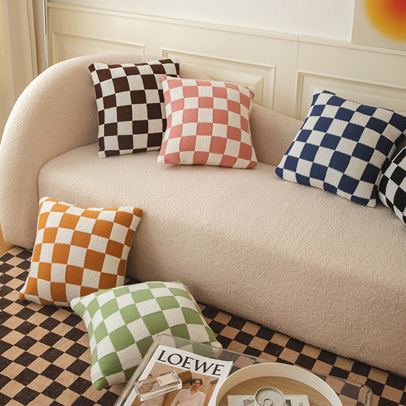 VibeCore Checkerboard Throw Pillow Covers in various colors, displayed on a couch. Bold, timeless checkerboard pattern in a soft polyester-cotton blend, adding a chic, stylish touch to any living space.
