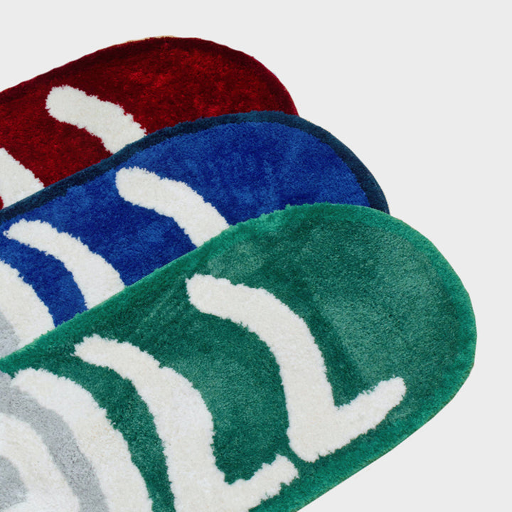 VibeCore Chill Pill Accent Rug close-up of red, green, and blue options, displaying the sleek pill shape and soft texture of each rug.