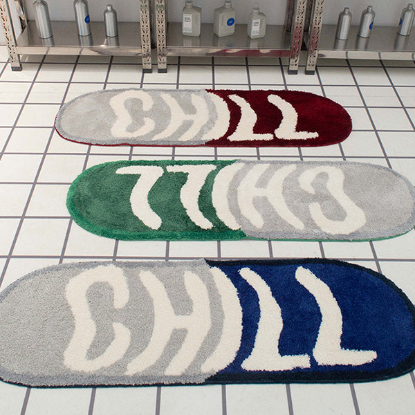 VibeCore Chill Pill Accent Rug in red, blue, and green versions displayed on a bathroom floor, showcasing their vibrant colors and unique pill shape in a stylish setting.