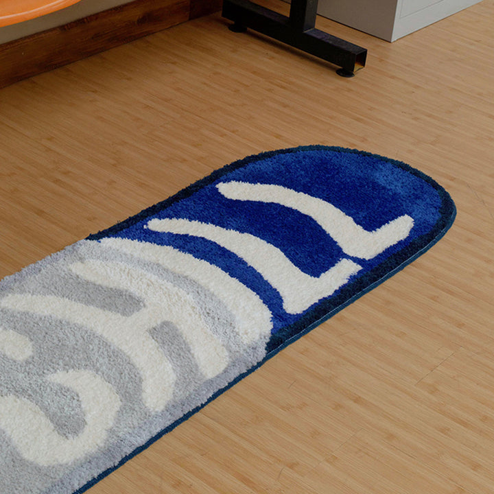 VibeCore Chill Pill Accent Rug blue version on a wooden floor, showcasing its vibrant color and modern pill shape in a cozy room setting.