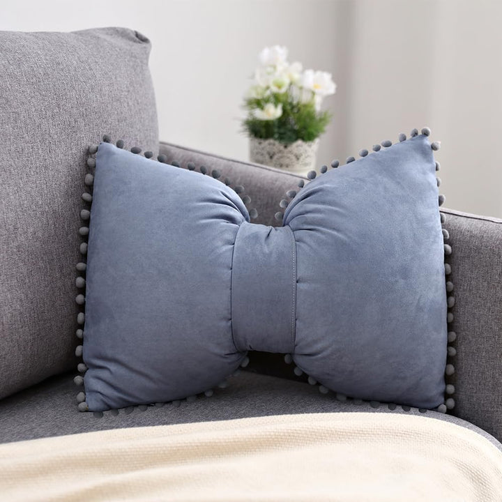 VibeCore Classic Bow Throw Pillow in blue gray, featuring a cute bow design with pom-poms around the edges, offering a chic and playful accent to any space.