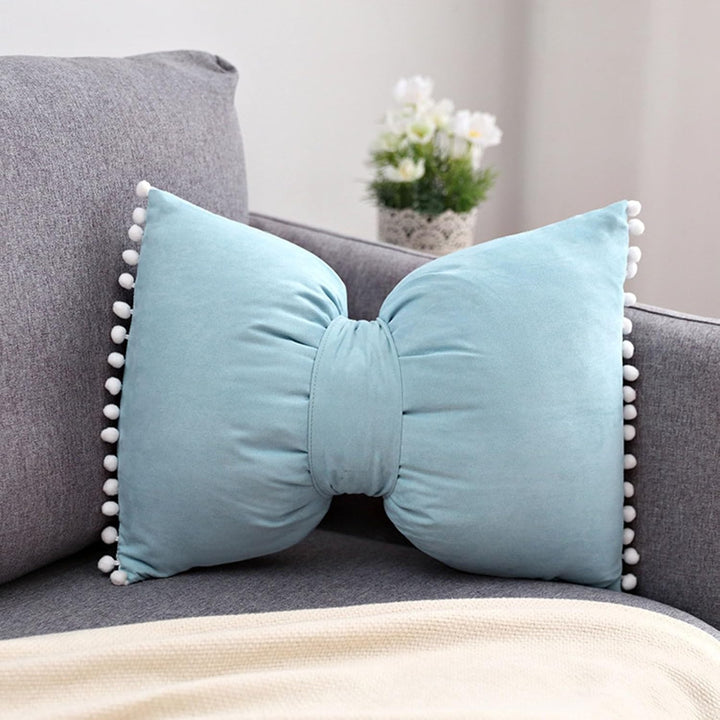 VibeCore Classic Bow Throw Pillow in sky blue, with a playful bow shape and pom-pom details, adding a charming, soft touch to your decor.