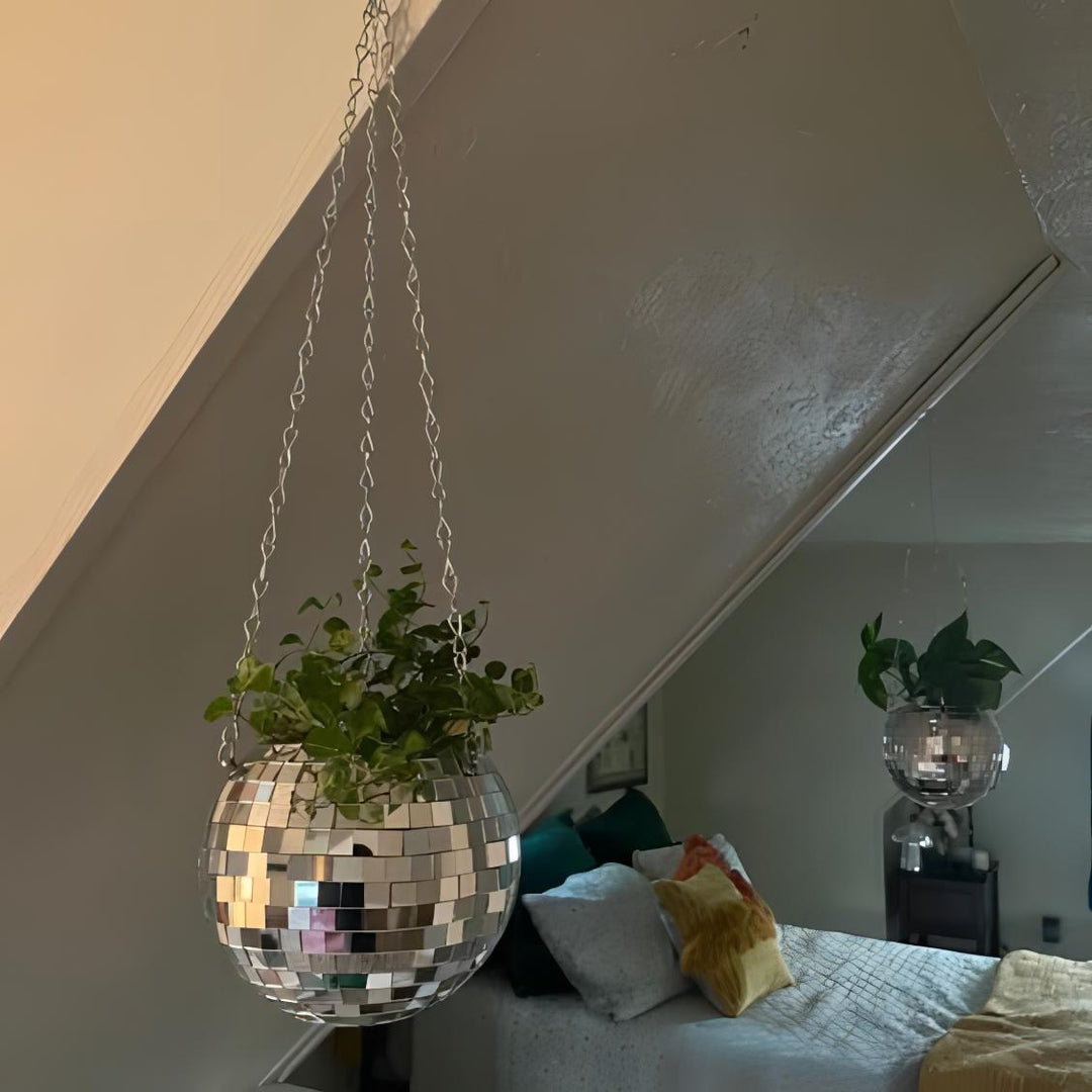 VibeCore Disco Ball Planter hanging in bedroom, featuring a shiny, reflective mirror-ball surface. This unique, retro-inspired planter adds a playful and stylish touch to your space while showcasing your plants. The disco ball design brings a fun, vibrant atmosphere to your bedroom decor, making it an eye-catching focal point.