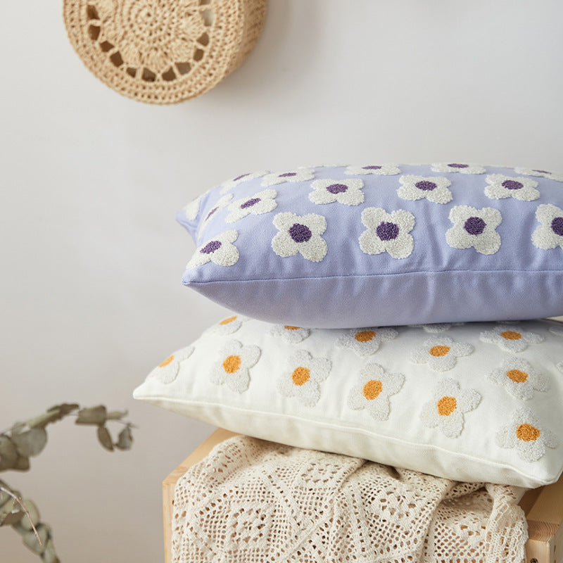 Lavender and white rectangle throw pillow covers with hand-stitched embroidered daisies, stacked on top of one another. The fresh floral design, crafted from soft, breathable cotton, adds a cozy and elegant touch to any space, featuring concealed zippers for a polished and functional look.
