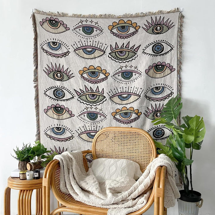 VibeCore Eternal Gaze Woven Blanket as wall hanging, showcasing its captivating and bold design. Made from soft, breathable 100% combed cotton, it adds depth, mystique, and vibrant energy to your space, transforming any wall into an eye-catching focal point.
