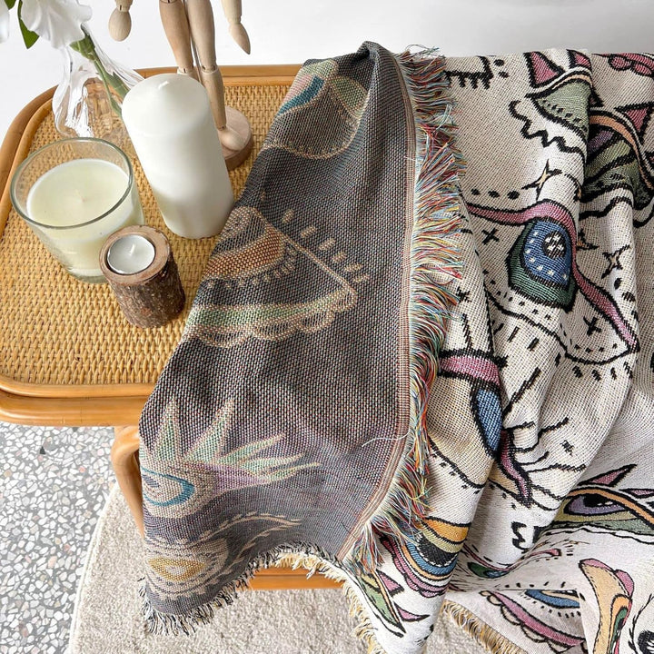 VibeCore Eternal Gaze Woven Blanket reversible feature, showcasing two distinct designs. Crafted from soft, breathable 100% combed cotton, it offers versatile style changes, allowing you to easily switch up the look of your space with a bold and captivating pattern on each side.