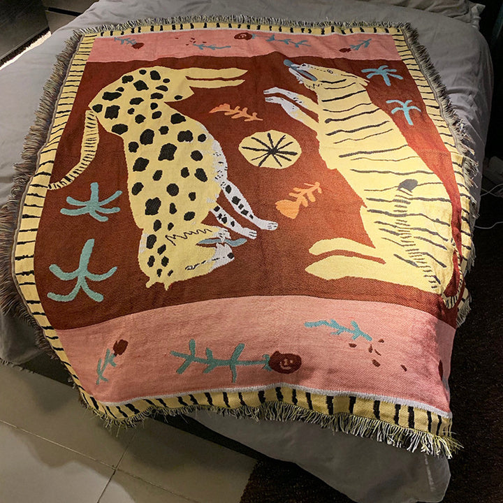 VibeCore Feline Power Woven Blanket spread over bed, featuring a bold jungle design in soft 100% cotton for a striking and comfortable look.
