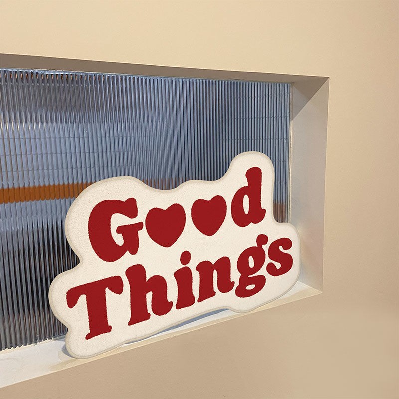 Aesthetic red "Good Things Accent Rug" placed on a windowsill, featuring a motivational Y2K message. The soft, plush texture adds a cozy touch, while the vibrant design brings warmth and positivity to the space, making it a unique addition to any room.