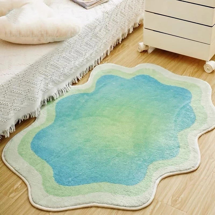 The VibeCore Gradient Wave Accent Rug in green placed by a bed, adding a fresh and modern touch to the room. The fluid gradient design enhances the aesthetic while providing comfort and style to the space.