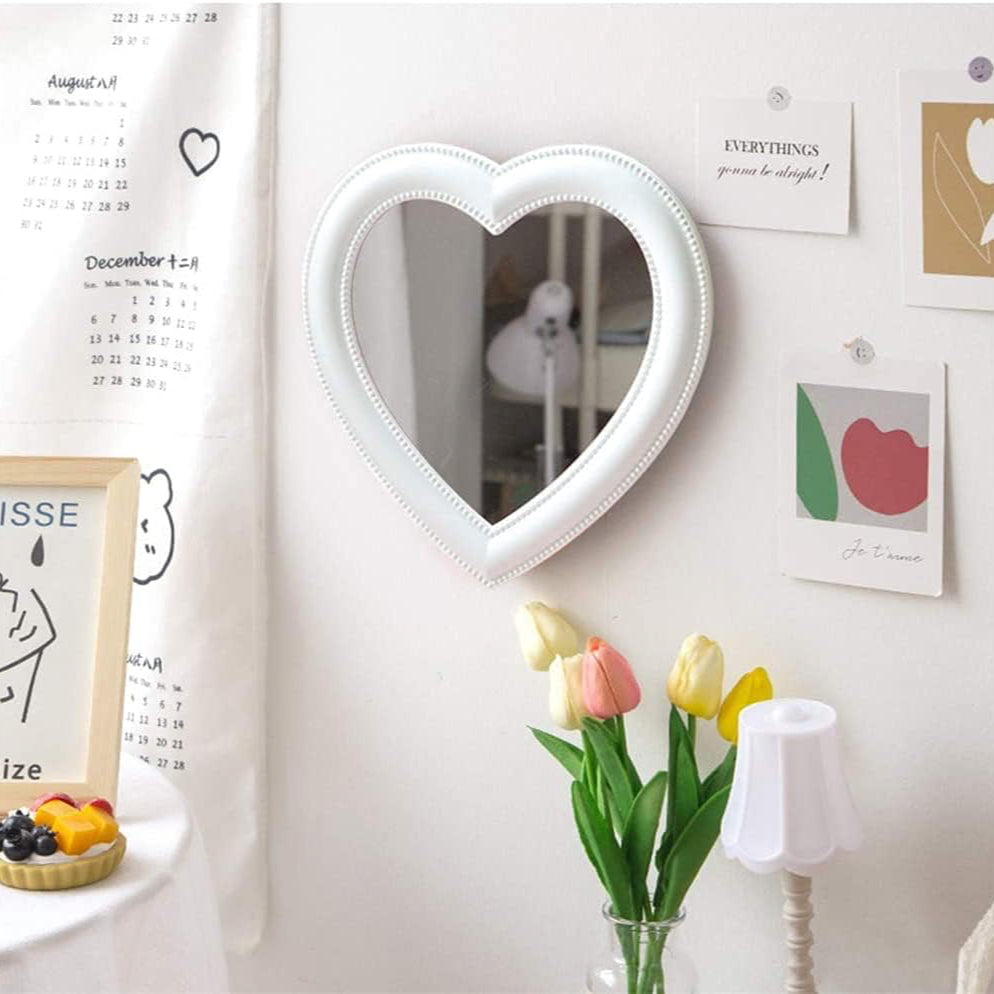 VibeCore Heart-Shaped Mirror in White, displayed on a wall, adding a soft, aesthetic touch to the room. Ideal for a coquette or cutecore-inspired space, this mirror enhances any teen room, dorm room, or bedroom with its minimalist design. Its white hue brings a fresh, clean vibe, making it perfect for those seeking a charming and trendy decor piece in their modern space.