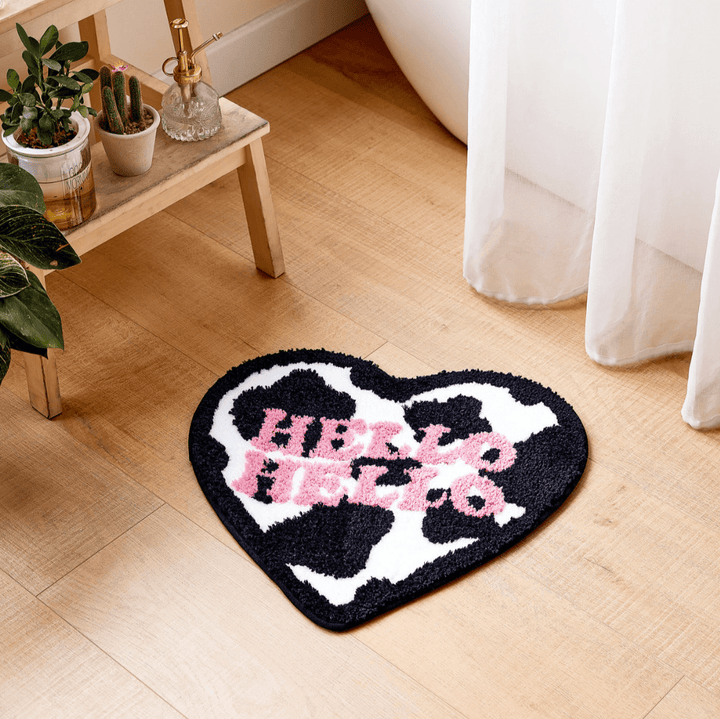 VibeCore Hello Hello Cow-Print Heart Rug in a bathroom, showcasing its playful cow-print heart design, adding a quirky touch to the space. Perfect for adding fun and comfort to any room