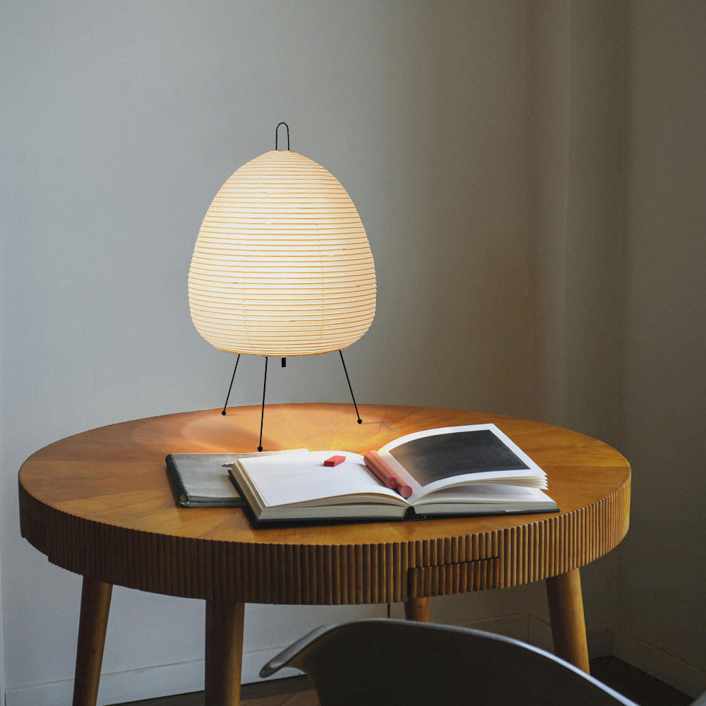 VibeCore Japanese Wabi Sabi Rice Paper Table Lamp on a side table, showcasing its minimalist design with a soft, organic rice paper shade and a sleek aluminum base.