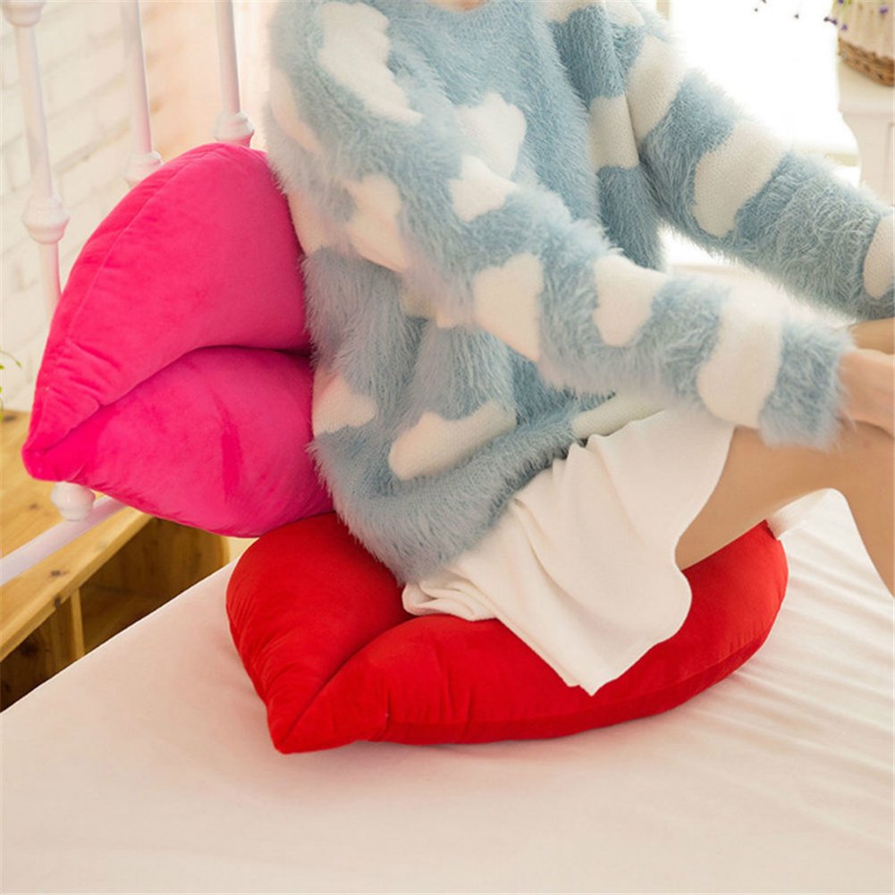 VibeCore Lips Throw Pillow in red and pink, with a girl sitting on top of the pillows. Bold, playful lip-shaped design in ultra-soft velvet plush, adding a fun, stylish touch to any space.
