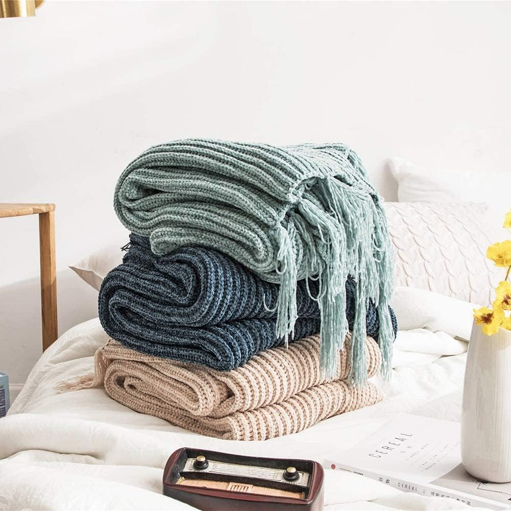 Aqua, blue, and beige Long Tassel Knitted Throw Blankets folded on one another, highlighting their chic tassel designs and ultra-soft, premium comfort. A stylish and cozy addition to any space.