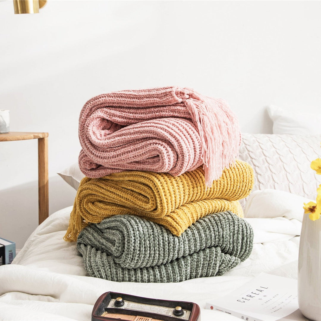 Light pink, yellow, and sage Long Tassel Knitted Throw Blankets folded on one another, showcasing their chic tassel designs and ultra-soft, high-quality comfort. A perfect blend of style and warmth, ideal for any cozy space.