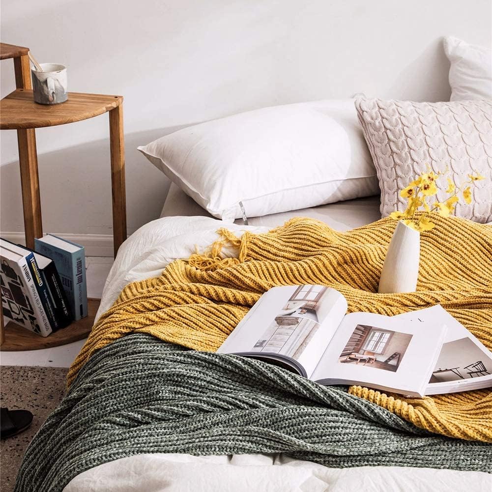 Yellow and sage Long Tassel Knitted Throw Blanket draped on a bed, showcasing its chic tassel design and ultra-soft comfort. A stylish, cozy accent perfect for adding warmth and color to any bedroom.
