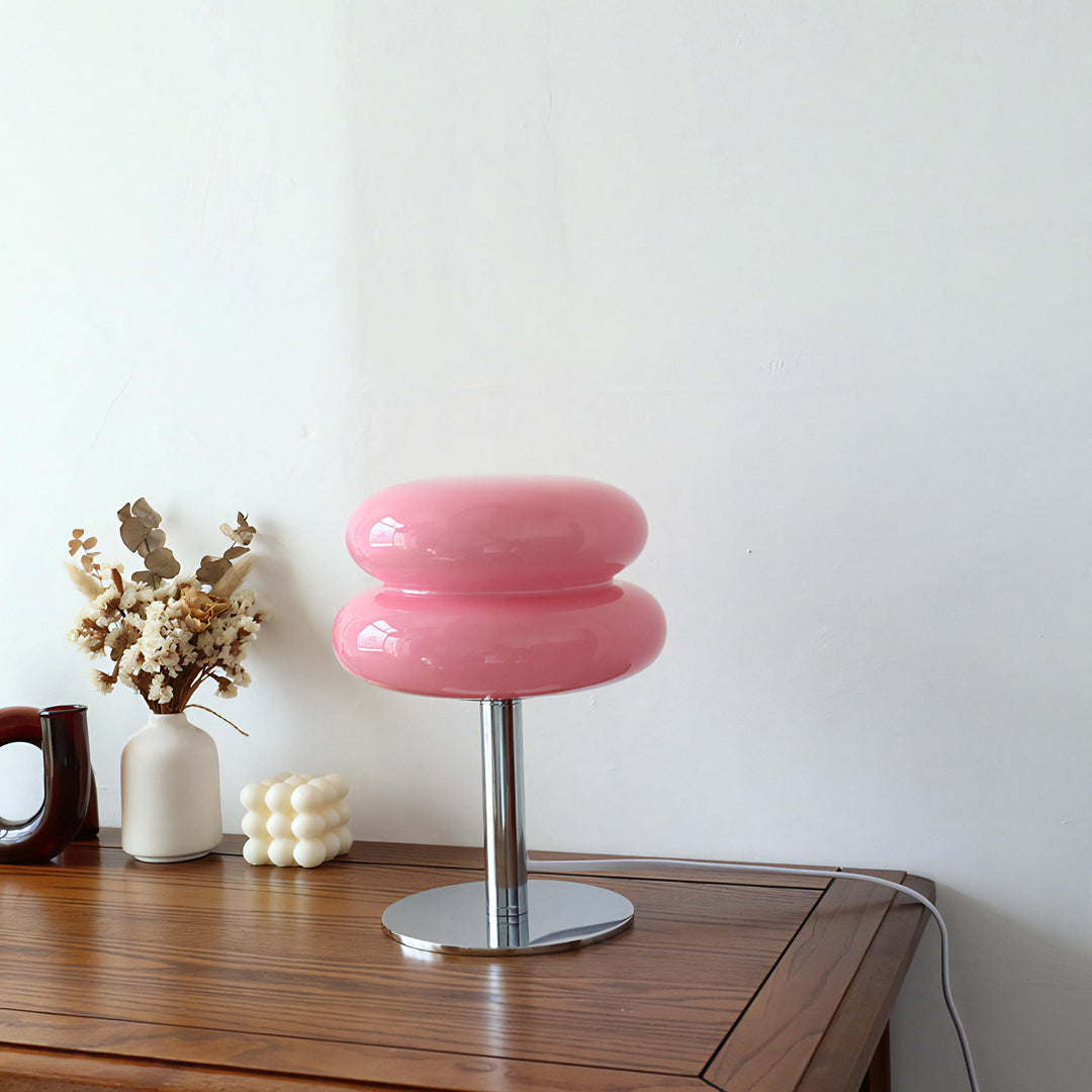 VibeCore Macarons Glass Table Lamp in pink, unlit, placed on a table, showcasing its elegant Bauhaus-inspired design and pastel color.