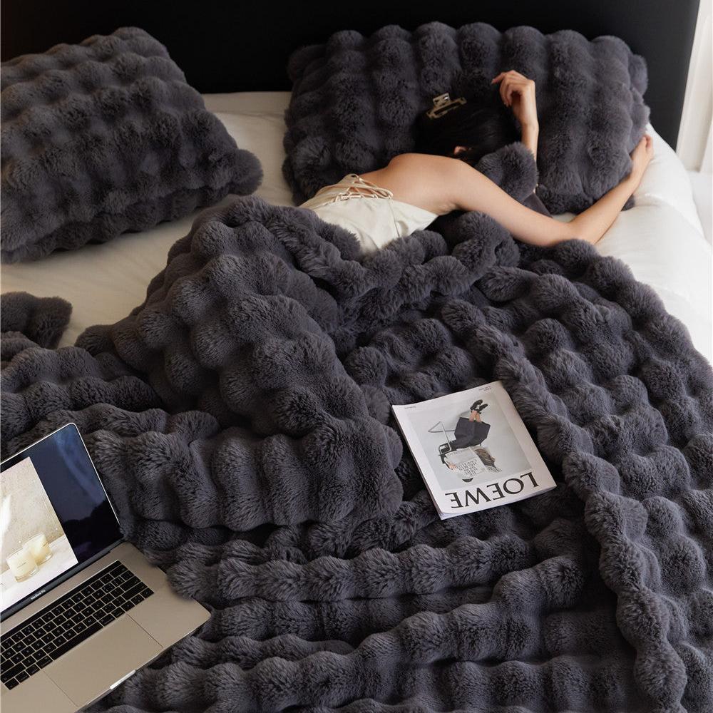 VibeCore Marshmallow Ultra Plush Blanket Black With Woman Cuddled In It In Bed, demonstrating it's aesthetic and cozy features.