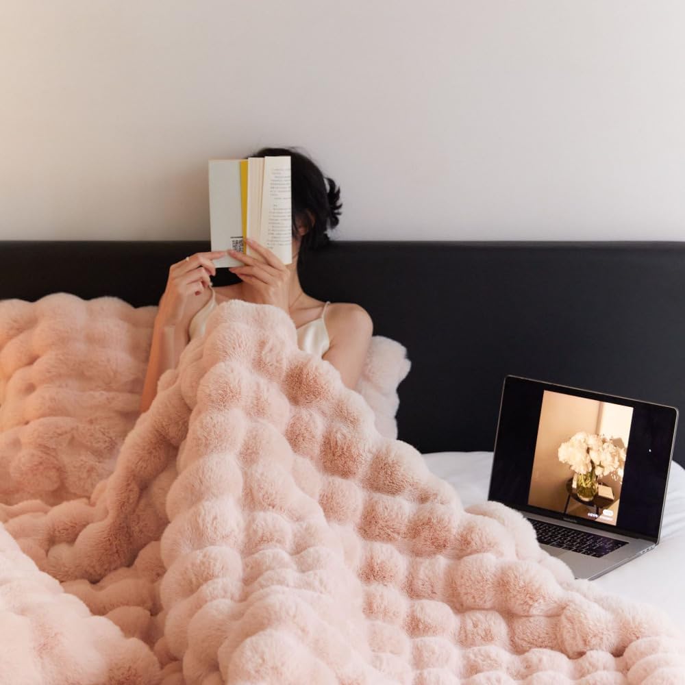 VibeCore Marshmallow Ultra Plush Blanket Blossom With Woman Cuddled In It While Reading, perfect for getting cozy in luxury.