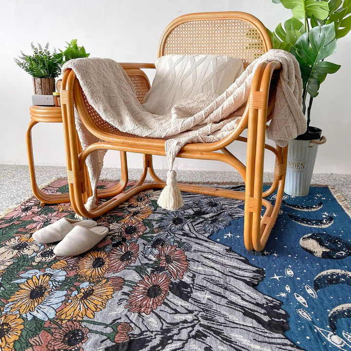 VibeCore Midnight Mountain  Woven Blanket as a rug under chair, showcasing a mountain-inspired design and soft 100% combed cotton texture.