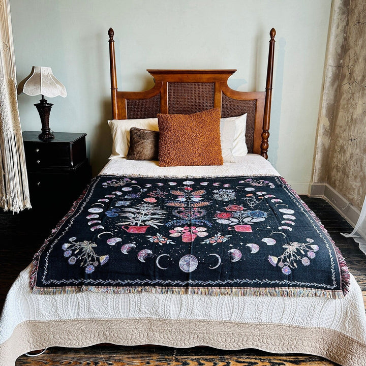 VibeCore Mystic Bloom Woven Blanket draped over a bed, showcasing its enchanting floral design and soft, luxurious cotton texture, adding a mystical touch to the room.