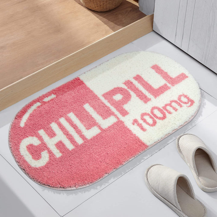 VibeCore Pink Chill Pill Accent Rug aerial side view highlighting its cute Nordic-style oval shape and soft pink hue. This playful rug is perfect for adding a quirky touch to bedrooms, dorms, bathrooms, or living rooms. The fun rug features a soft, plush texture and non-slip bottom, making it ideal as a bath mat or decorative rug. Its contemporary design and water-absorbent properties offer both comfort and style, making it a low-maintenance, easy-to-clean accent rug that enhances any space with its vibrant