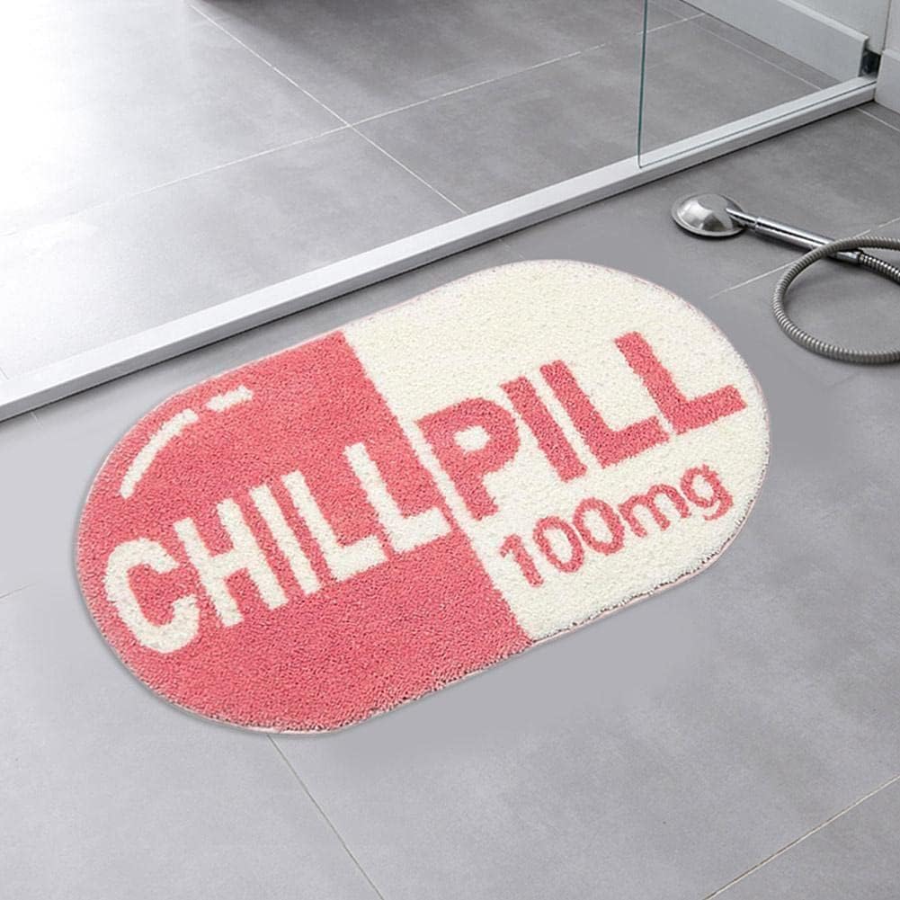 VibeCore Pink Chill Pill Accent Rug aerial view showcasing its cute Nordic-style oval shape and soft pink aesthetic. Perfect for bedrooms, dorms, bathrooms, or living rooms, this pink rug adds a playful, quirky touch. Ideal as a fun rug, bath mat, or decorative rug with a soft, plush texture and non-slip bottom for safety. A modern and contemporary addition to your space, combining comfort and style. This aesthetic rug is easy to clean, durable, and water-absorbent, offering both functionality and personali