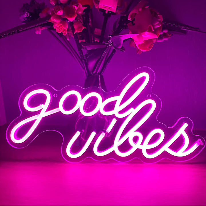 The VibeCore Pink Good Vibes Cursive Neon Light, standing upright, offers a chic and cheerful glow that adds a positive atmosphere to any space. Its vibrant, cursive lettering makes it an eye-catching decor piece for bedrooms, lounges, or dorms.