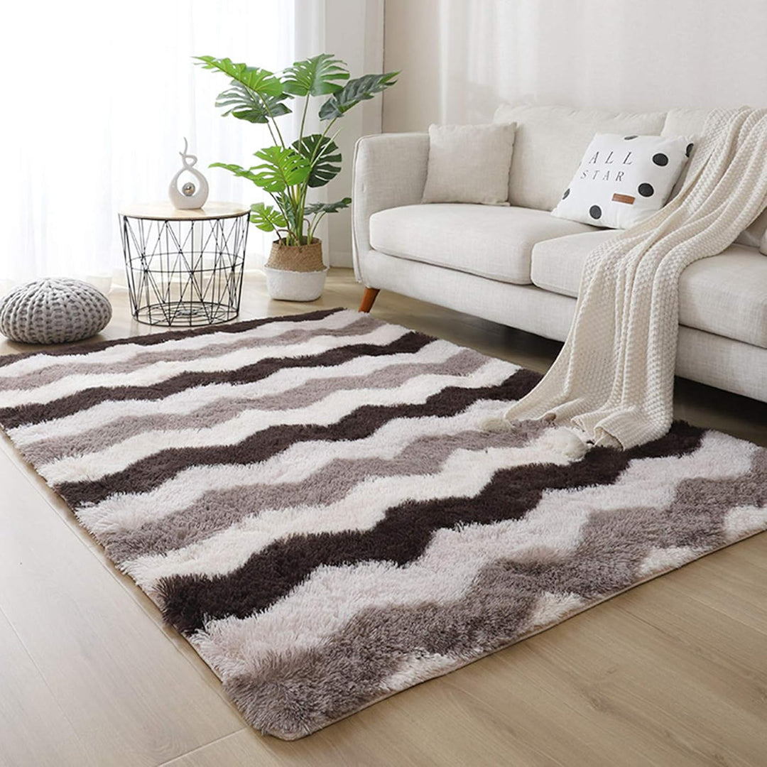 VibeCore Plush Patterned Area Rug in brown zigzag pattern, placed in a living room, featuring a soft polyester fiber texture and non-slip backing. Adds a cozy and stylish touch to your space. Easy to clean and available in 5 stylish options.