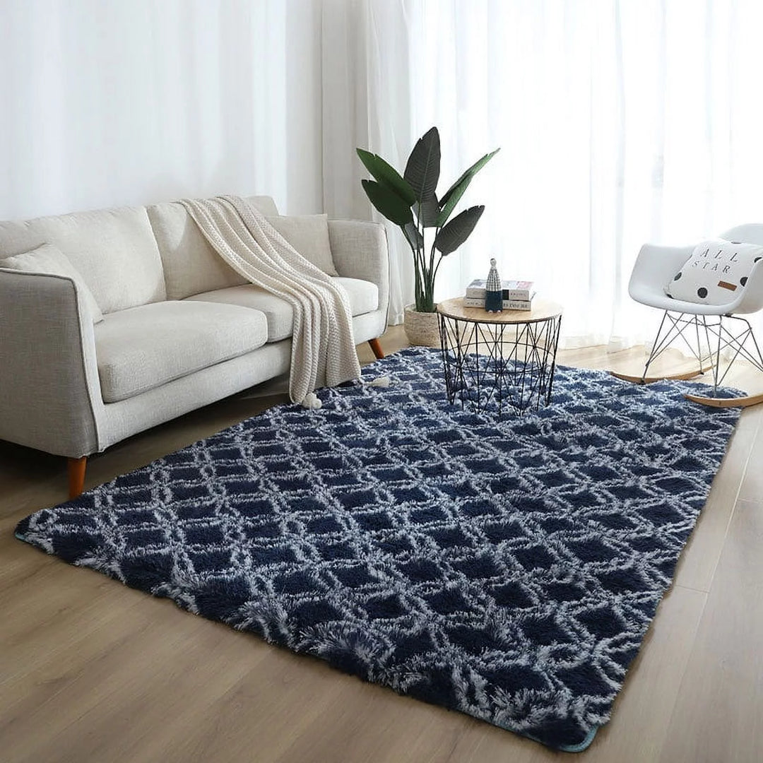 VibeCore Plush Patterned Area Rug in white design on a blue background, placed in a living room, featuring a soft polyester fiber texture and non-slip backing. Adds comfort and style to your space. Easy to clean and available in 5 stylish options.