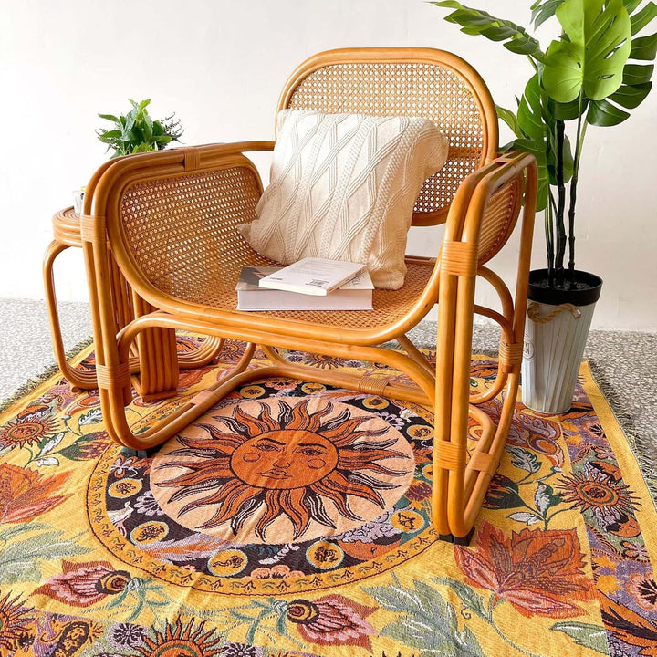 VibeCore Radiant Sun Woven Blanket as a rug under chair, showcasing vibrant boho-sun design and soft 100% combed cotton texture.