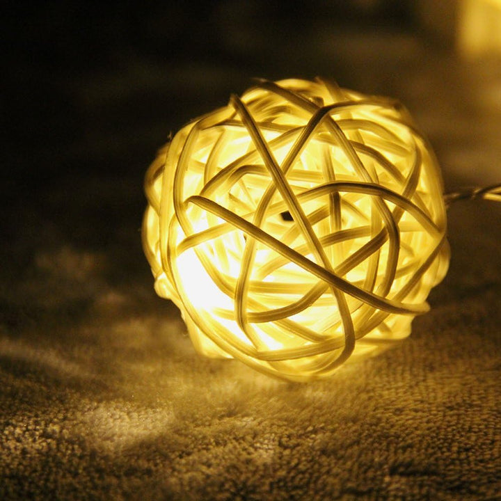 Close-up of a single VibeCore Rattan Ball from the string lights, featuring its natural texture and warm glow.