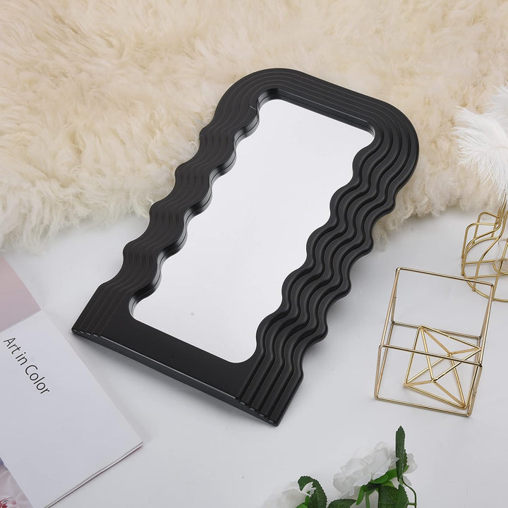 VibeCore Retro Wave Mirror in black, placed on the floor, highlighting its wave-shaped resin frame and sleek mirror lens, adding a bold, retro-inspired statement to the room.