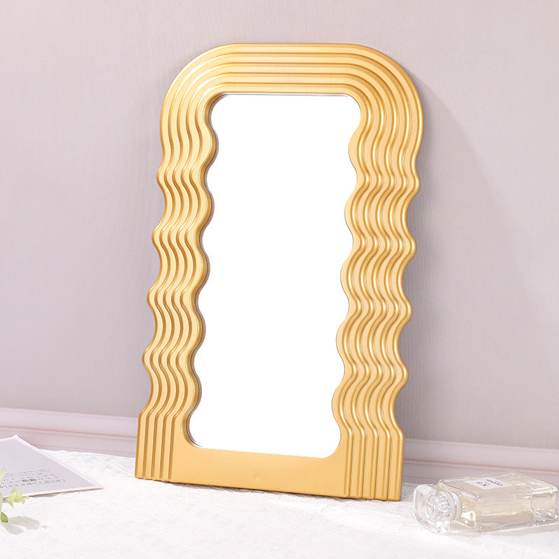 VibeCore Retro Wave Mirror in gold, displayed against a wall, showcasing its stylish wave-shaped resin frame and reflective surface that enhances the space with a touch of modern flair.