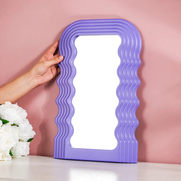 VibeCore Retro Wave Mirror in purple, shown next to a hand for size comparison, highlighting its sleek wave-shaped resin frame and compact design.