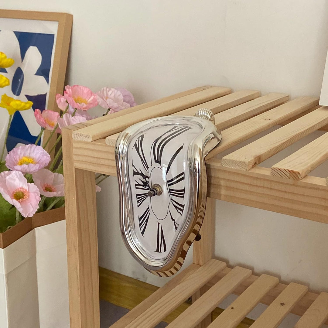 VibeCore Salvador Dali's Melting Clock in Silver draped over a wooden console table, combining surrealist art with functional timekeeping for a unique decor statement.