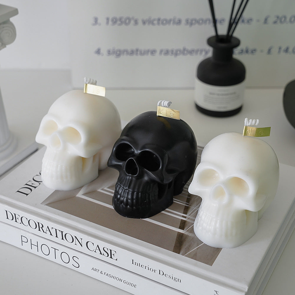 Two white scented skull candles and one black scented skull candle, featuring bold, striking designs and captivating fragrances, perfect for adding an edgy touch to your room decor.
