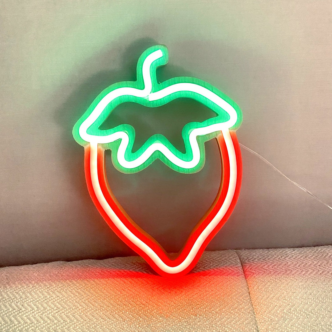 VibeCore Strawberry Neon Light Red against a wall, creating a playful and vibrant glow to enhance your room's vibe.