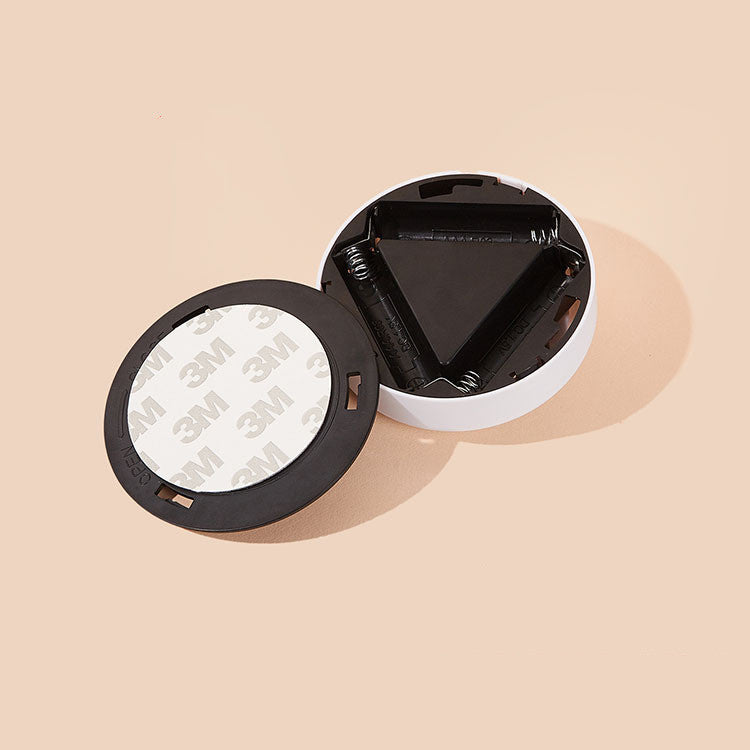Close-up of the back of the VibeCore Sunset Puck Light, highlighting its adhesive backing and battery compartment for easy installation.