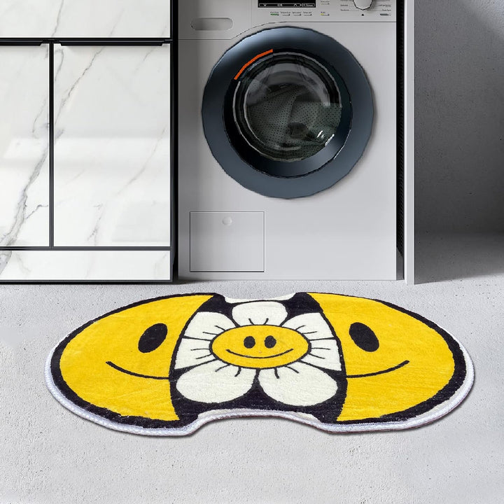 VibeCore Sunshine Split Smiley Accent Rug in front of a washing machine, featuring a playful design with a smiling face splitting open to reveal a vibrant sunflower, adding a fun touch to the laundry area.