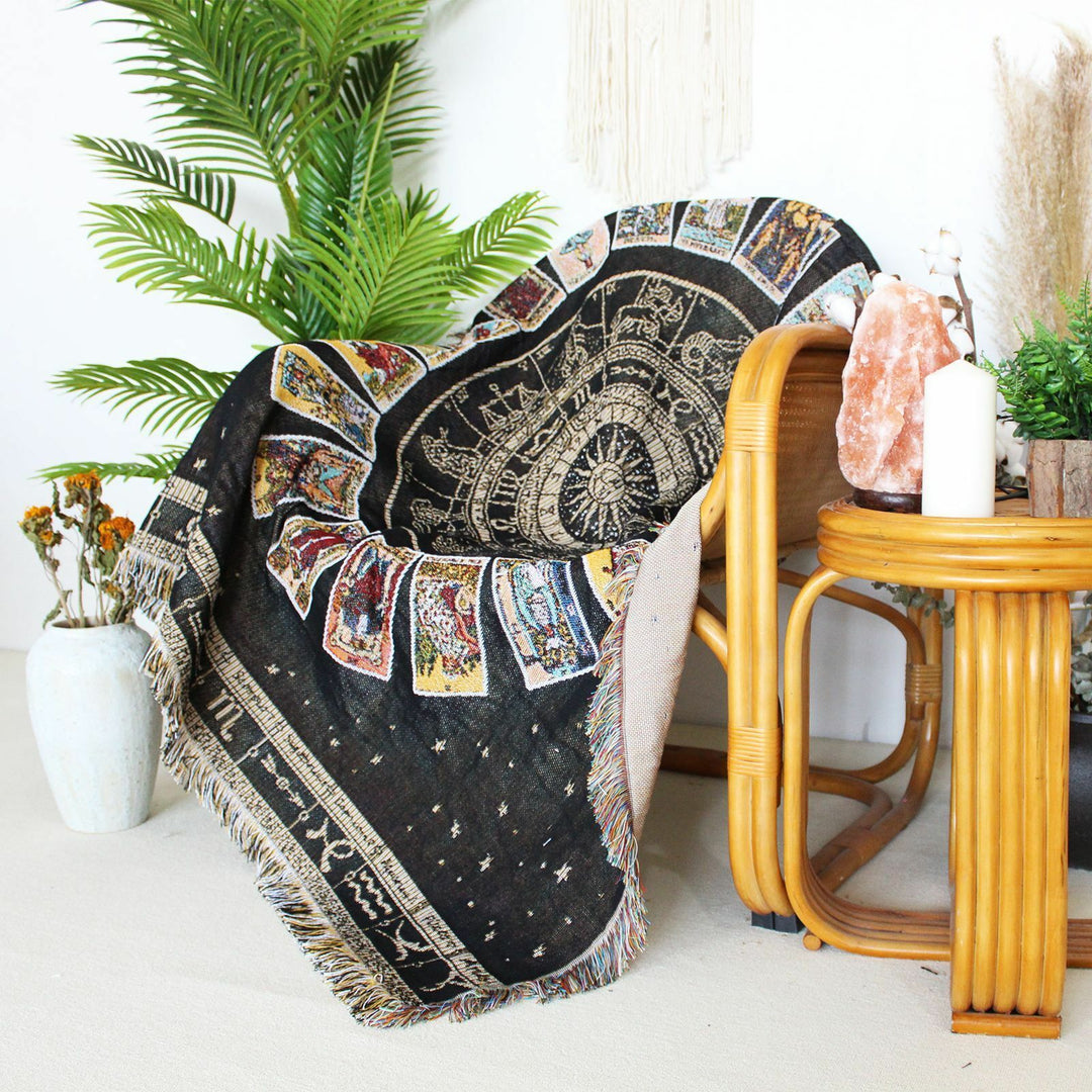VibeCore Tarot Card Mandala Woven Blanket on chair, featuring an intricate mandala and tarot card-inspired design. Crafted from soft, breathable 100% combed cotton, it adds a mystical, artistic touch and vibrant style to your space.