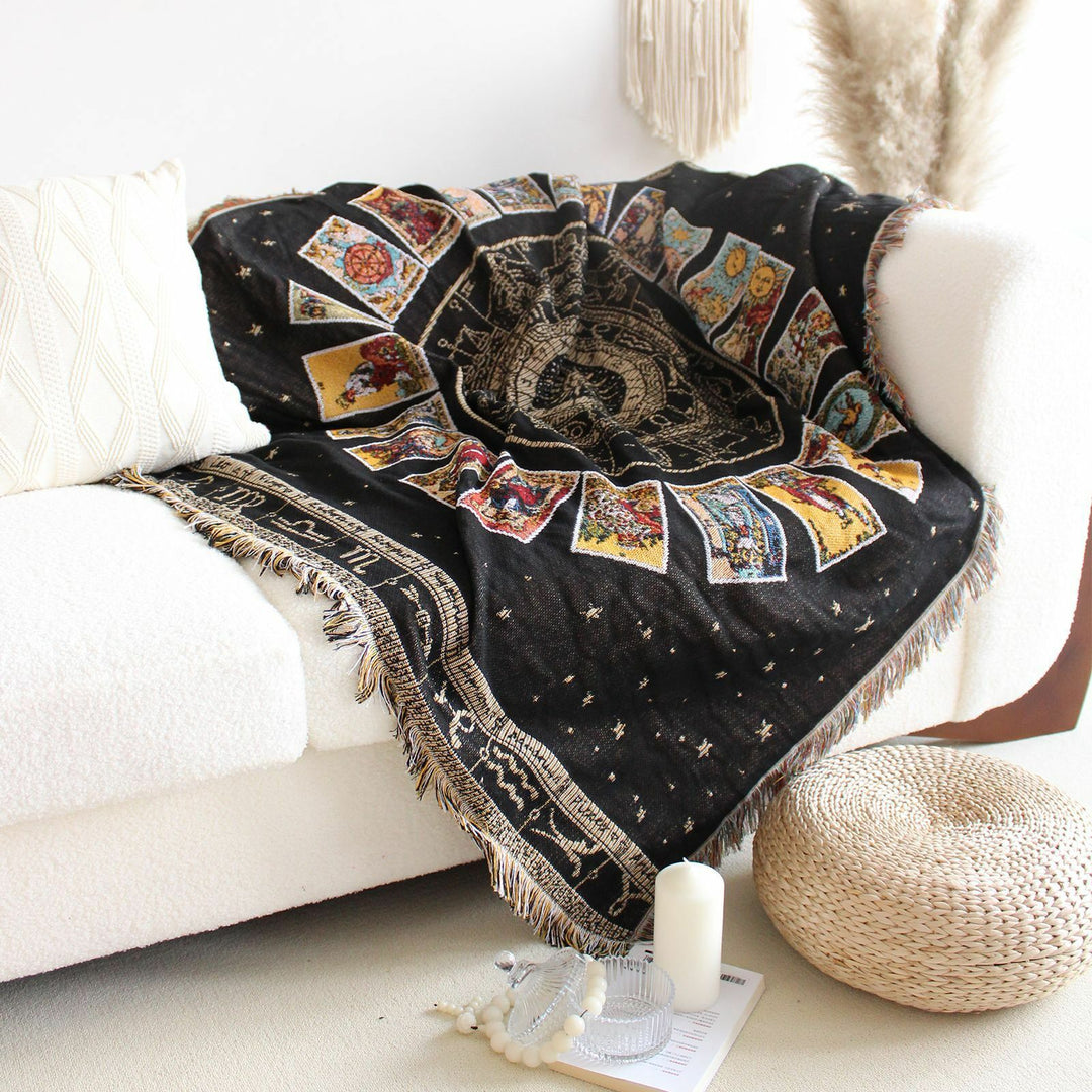VibeCore Tarot Card Mandala Woven Blanket on couch, featuring a spiritual-inspired design with intricate mandalas and tarot card motifs. Crafted from soft, breathable 100% combed cotton, it adds a mystical, vibrant touch to your living space.
