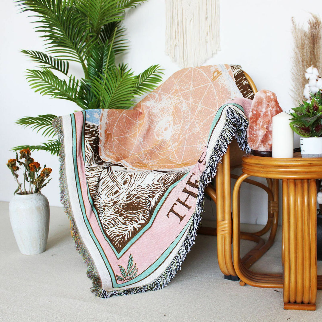 VibeCore The Star Tarot Woven Blanket draped over a chair, showcasing its celestial-inspired design and vibrant colors, adding an artistic touch to the space.