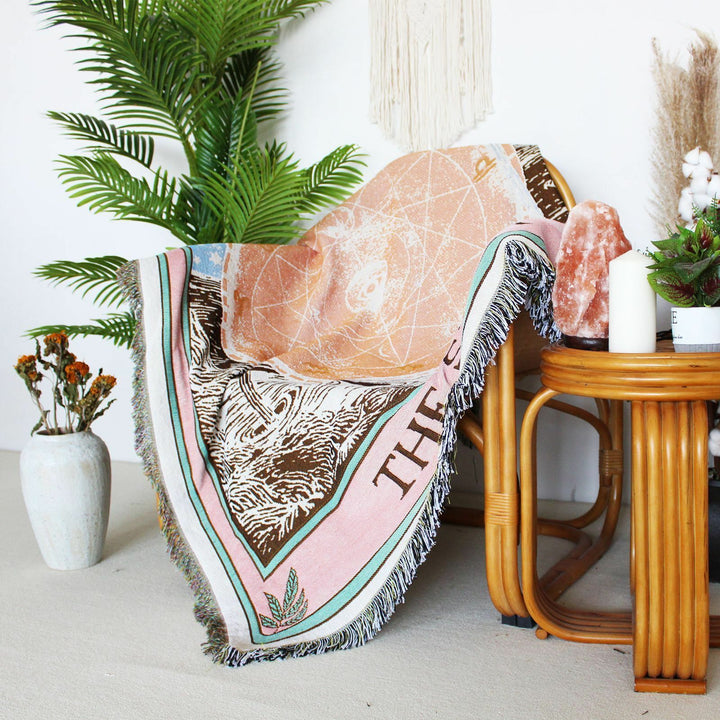VibeCore The Star Tarot Woven Blanket draped over a chair, showcasing its celestial-inspired design and vibrant colors, adding an artistic touch to the space.