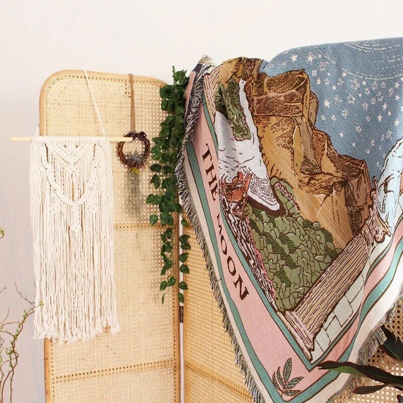 VibeCore The Sun Tarot Woven Blanket on room divider, alternative view, highlighting its celestial-inspired design with vibrant, reversible patterns. Made from soft, breathable 100% combed cotton, it adds a cosmic, artistic flair to your space while serving as a stylish and functional divider.