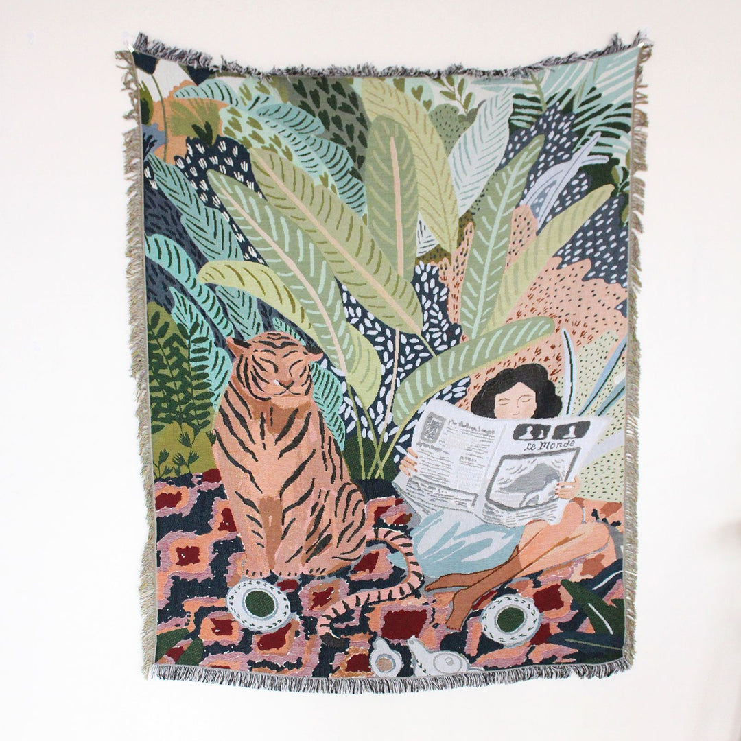 Product view of the Tiger Lounge Woven Blanket, showcasing its artistic-inspired design and 100% combed cotton material. The reversible patterns offer two striking looks, making it a versatile and stylish addition to any room.